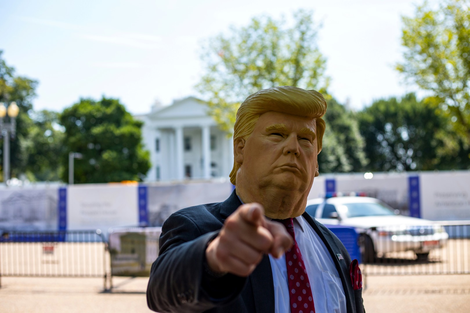 Topeng berwajah Presiden Amerika Serikat (AS) Donald Trump yang dipakai oleh seseorang di depan Gedung Putih. (Foto: Unsplash/Darren Halstead)