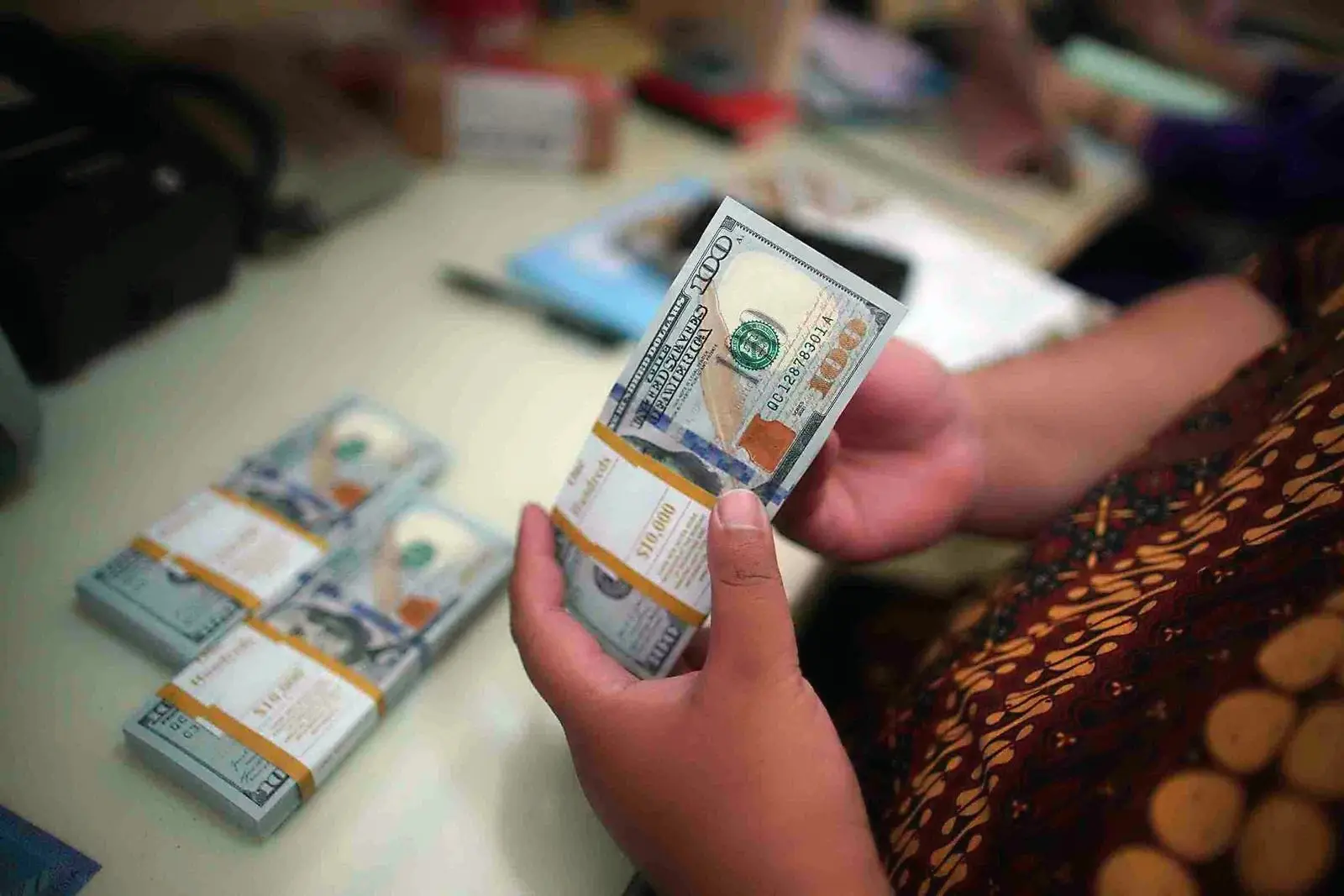 Pegawai menghitung uang dolar Amerika Serikat (USD) saat melayani pengunjung yang menukarkan valas ke rupiah di La Tunrung Money Changer, Juanda, Selasa, 11 Maret 2025. Nilai tukar dolar saat itu berada di kisaran Rp16.000 per dolar AS. (Foto: KabarBursa/Abbas Sandji)