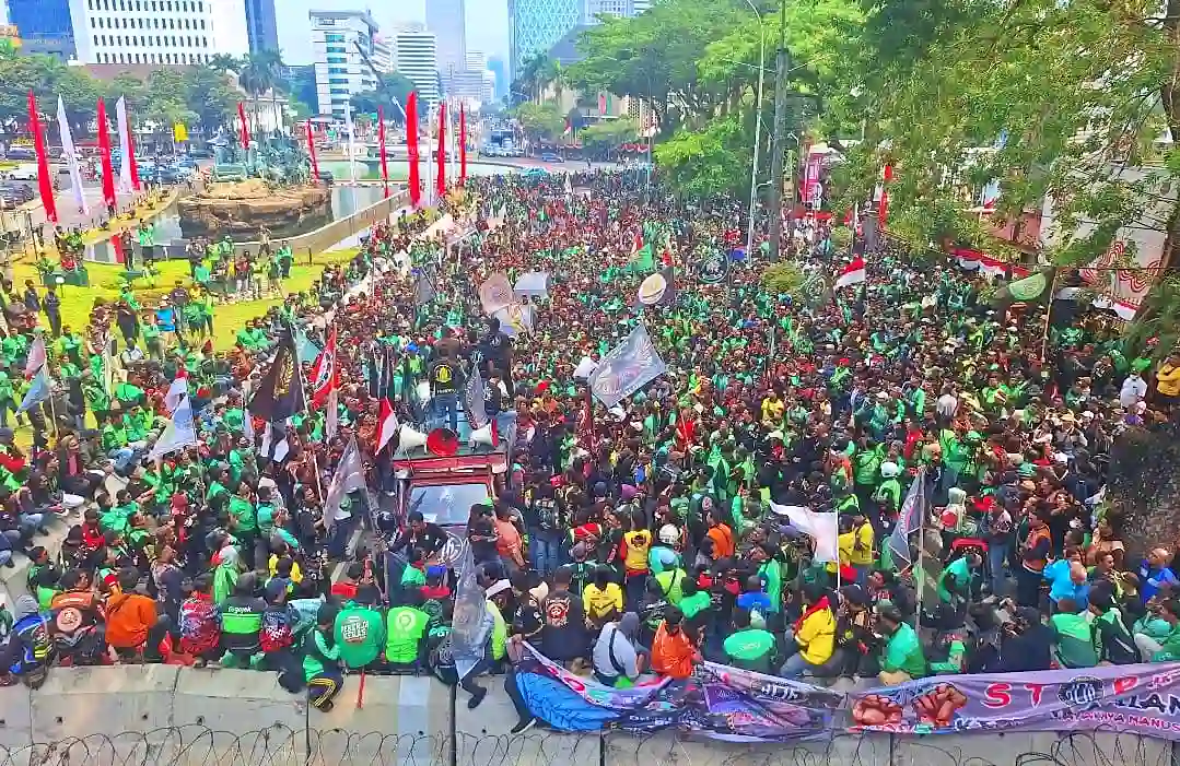 Ribuan pengemudi ojek online memenuhi kawasan Patung Kuda, Jakarta Pusat, dalam aksi unjuk rasa menuntut keadilan ekonomi dan pembagian komisi aplikator. (Foto: X/@Drixsetiawan)