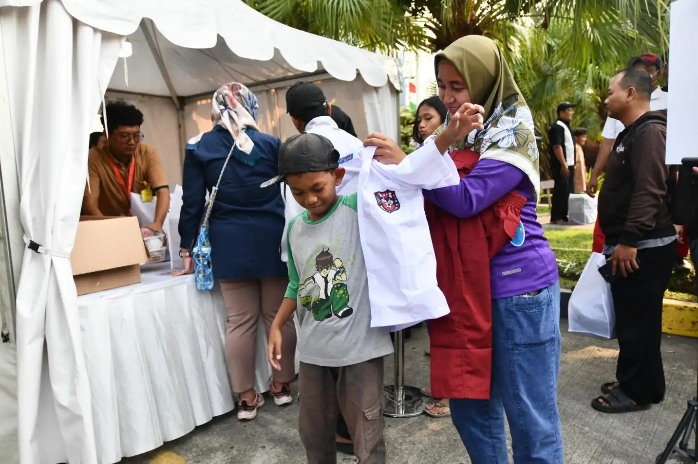 Seorang pSD elajar menerima baju seragam program Seribu Seragam Sekolah Bersama Pertamina (SESAMA). Foto: Pertamina.
