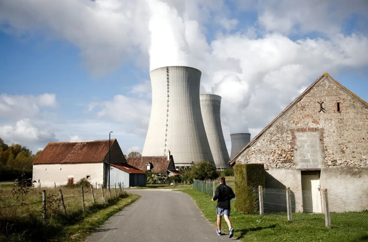 Uap mengepul dari menara pendingin pembangkit listrik tenaga nuklir Electricite de France (EDF) di belakang rumah-rumah di Dampierre-en-Burly, Prancis, 12 Oktober 2021. Foto: Reuters via Daily Sabah