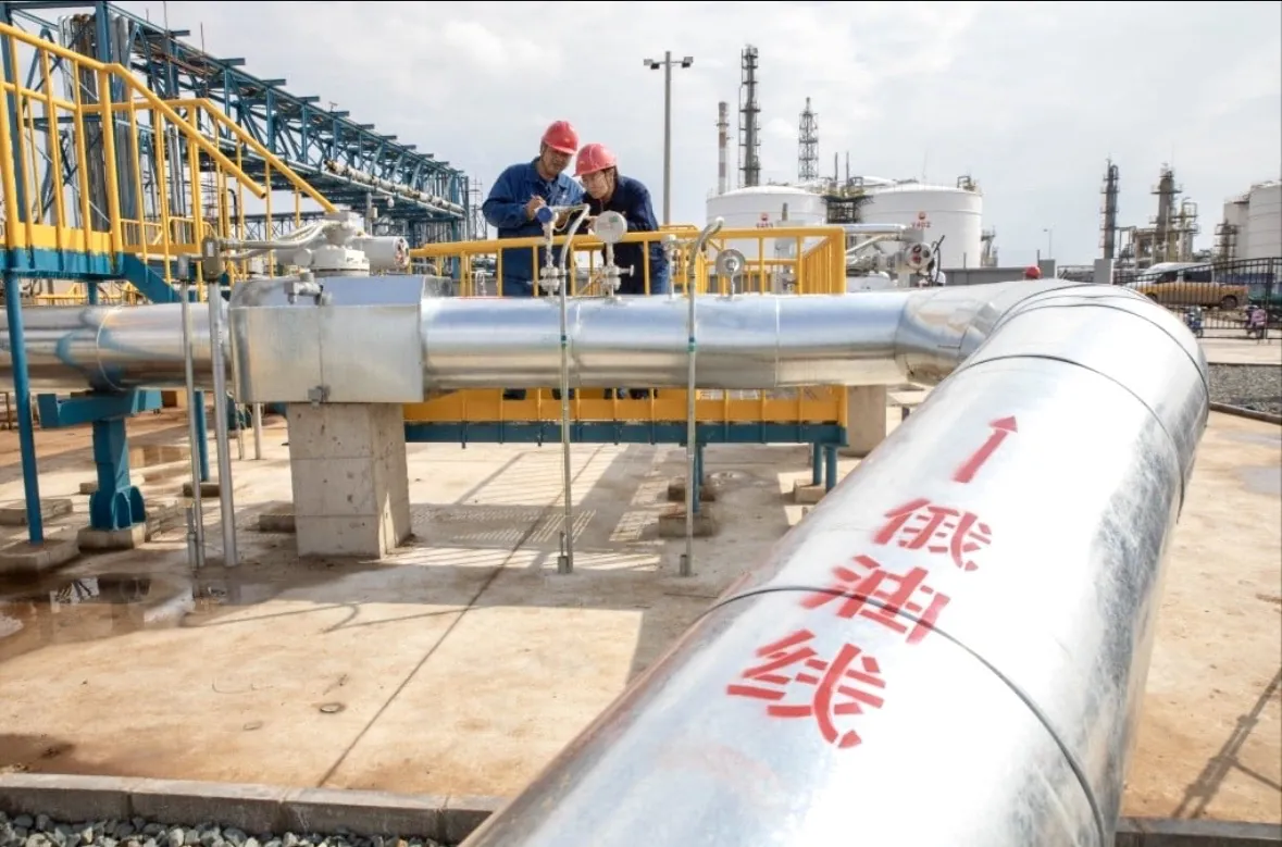 Para karyawan memeriksa peralatan yang digunakan di kilang minyak mentah di provinsi Heilongjiang, Tiongkok, yang berbatasan dengan Rusia. Foto: Getty Images via SCMP